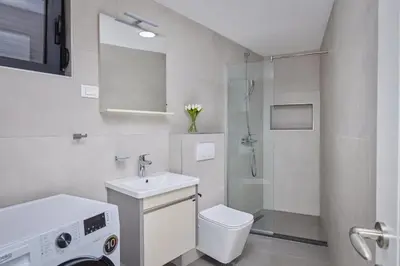 a bathroom with a sink and a toilet and a shower at Berge Apartments in Kotor