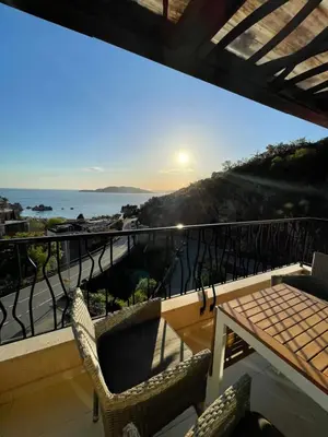a balcony with a table and chairs and the ocean at Miločer Apartman Beograd in Pržno