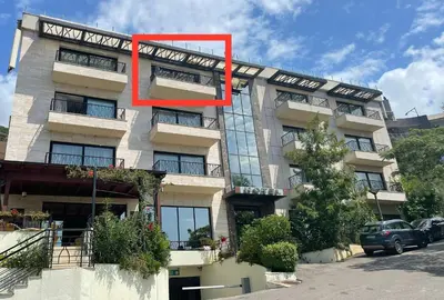 a building with a red sign on the side of it at Miločer Apartman Beograd in Pržno