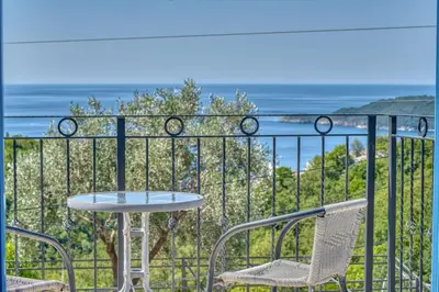 a table and chairs on a balcony overlooking the ocean at Villa Old Olive in Budva