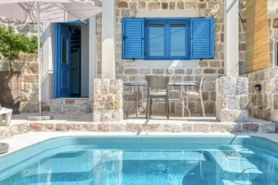 a pool in front of a house with a blue window at Villa Old Olive in Budva