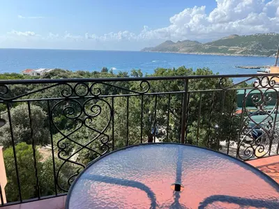 a glass table on a balcony with a view of the ocean at Apartment Sea View Dobra Voda in Dobra Voda
