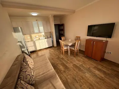 a living room with a table and a television at Apartment Sea View Dobra Voda in Dobra Voda