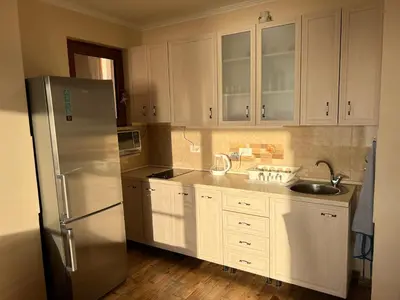 a kitchen with white cabinets and a stainless steel refrigerator at Apartment Sea View Dobra Voda in Dobra Voda