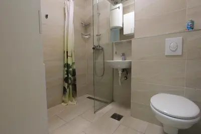 a bathroom with a shower and a toilet and a sink at Studio 13 Budva in Budva