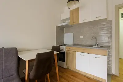 a small kitchen with a table and a sink at Studio 13 Budva in Budva
