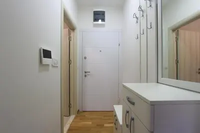 a white bathroom with a sink and a mirror at Studio 13 Budva in Budva