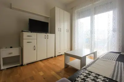 a bedroom with a bed and a tv on top of cabinets at Studio 13 Budva in Budva