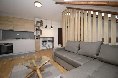 a living room with a couch and a glass table at Studio apartment Art Zone II in Podgorica