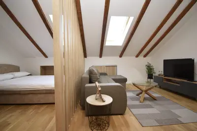 a living room with a couch and a bed at Studio apartment Art Zone II in Podgorica