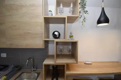 a kitchen with a sink and a counter with two wine glasses at Studio apartment Art Zone II in Podgorica