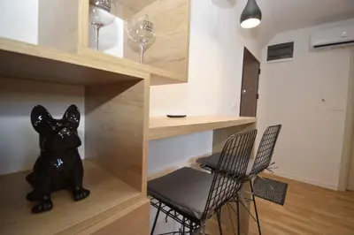 a room with a bar with two chairs and a dog statue at Studio apartment Art Zone II in Podgorica