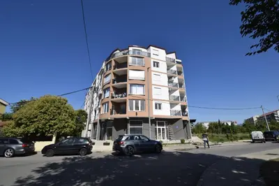 a tall building with cars parked in front of it at Studio apartment Art Zone II in Podgorica