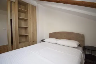 a bed with two white pillows in a bedroom at Studio apartment Art Zone II in Podgorica