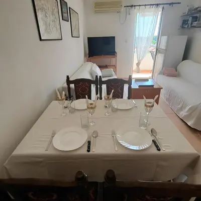 a table with plates and wine glasses on it at Coastal View Apartment in Bar