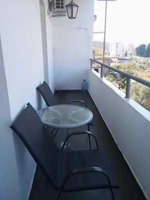 a table and chairs on a balcony with a window at Coastal View Apartment in Bar