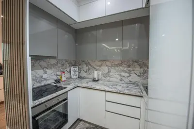 a kitchen with white cabinets and marble counter tops at Apartment Lara in Ulcinj