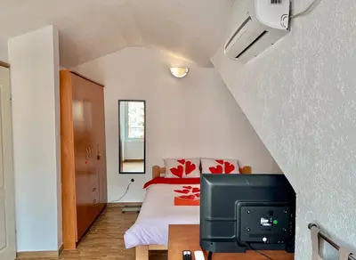 a bedroom with a bed and a tv in a room at Homestay Mark - DOUBLE BED ROOM - shared bathroom in Budva