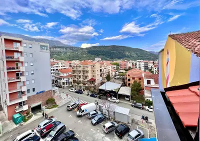 a city with cars parked in a parking lot at Homestay Mark - DOUBLE BED ROOM - shared bathroom in Budva