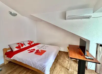a bedroom with a bed and a desk with a laptop at Homestay Mark - DOUBLE BED ROOM - shared bathroom in Budva