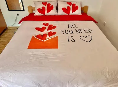 a bed with a sign that says all you need is love at Homestay Mark - DOUBLE BED ROOM - shared bathroom in Budva