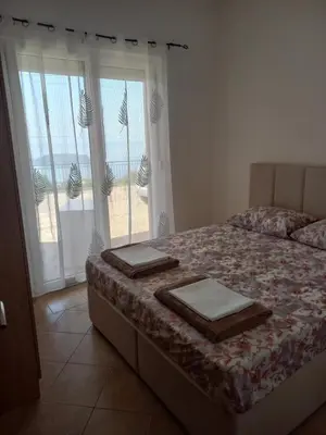 a bedroom with a bed and a large window at Apartmani Vujovic Markovici in Budva