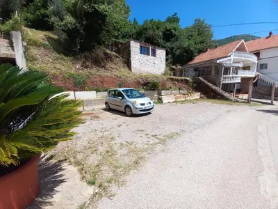 a small car parked in the driveway of a house at Apartmani Vujovic Markovici in Budva
