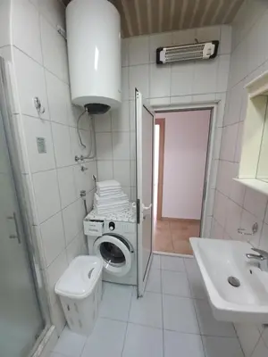 a white bathroom with a toilet and a sink at Apartmani Vujovic Markovici in Budva