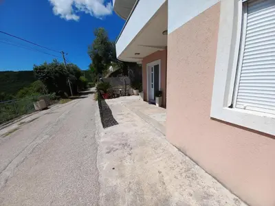 an empty street next to a pink building at Apartmani Vujovic Markovici in Budva