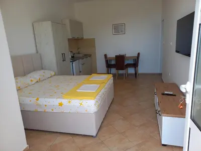 a small bedroom with a bed and a table at Apartmani Vujovic Markovici 2 in Budva