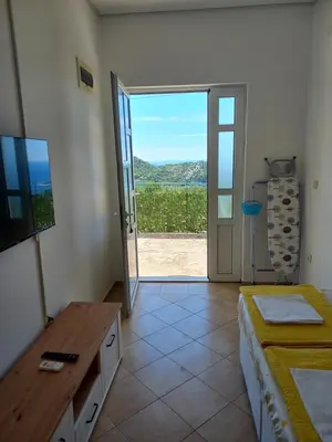 a room with a door open to a patio with a view at Apartmani Vujovic Markovici 2 in Budva
