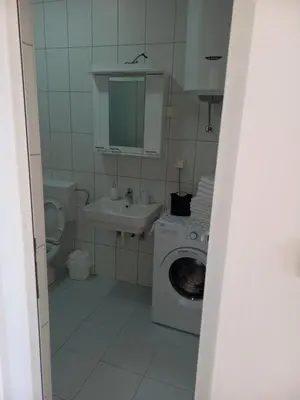 a bathroom with a washing machine and a sink at Apartmani Vujovic Markovici 2 in Budva
