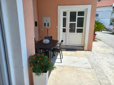 a patio with a table and chairs and a door at Apartmani Vujovic Markovici 2 in Budva
