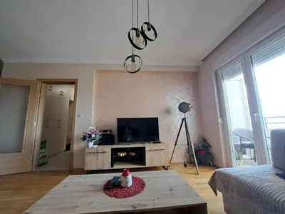 a living room with a tv and a table at VUCETIC Apartment- Podgorica in Podgorica