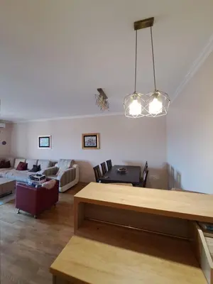 a living room with a table and a couch at VUCETIC Apartment- Podgorica in Podgorica
