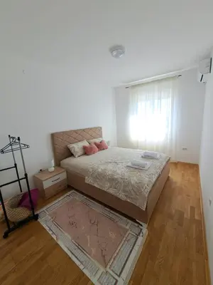 a bedroom with a large bed and a window at VUCETIC Apartment- Podgorica in Podgorica
