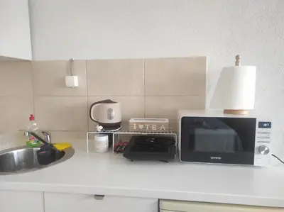 a kitchen counter with a microwave and a sink at Apartment Clock Tower in Podgorica