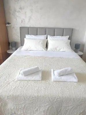 a large white bed with two pillows on it at Apartment Clock Tower in Podgorica
