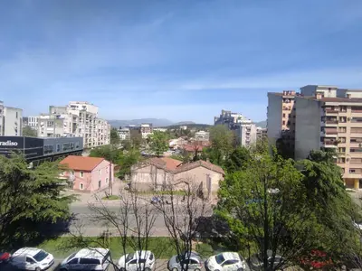 a city with cars parked in a parking lot at Apartment Clock Tower in Podgorica