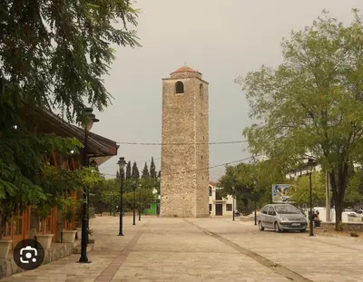 a tall tower with a car parked in front of it at Apartment Clock Tower in Podgorica