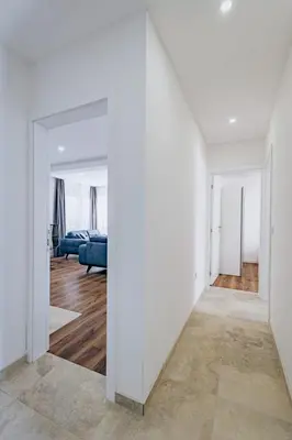 a hallway with white walls and a living room at Bečići lux in Ivanovići
