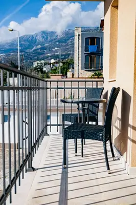 a patio with two chairs and a table on a balcony at Bečići lux in Ivanovići