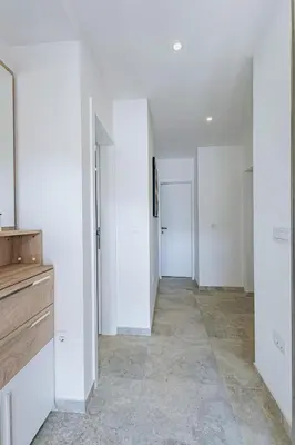 an empty hallway with white walls and white closets at Bečići lux in Ivanovići