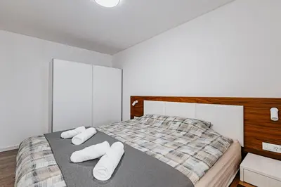 a bedroom with a bed with white towels on it at Bečići lux in Ivanovići