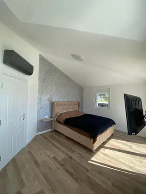 a bedroom with a bed and a flat screen tv at Vila Mikeli in Podgorica