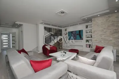 a living room with white furniture and red pillows at Vila Mikeli in Podgorica