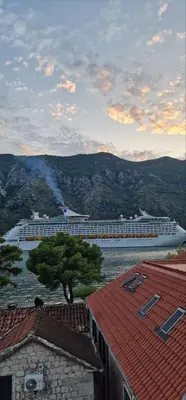 a large cruise ship in a body of water at Beautiful flat with sea view Aquamarine in Kotor