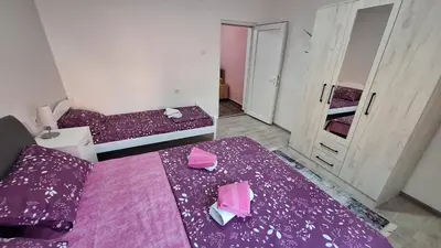 a room with two beds with purple sheets at Apartman Jelena in Cetinje