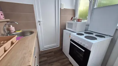 a small kitchen with a stove and a microwave at Apartman Jelena in Cetinje