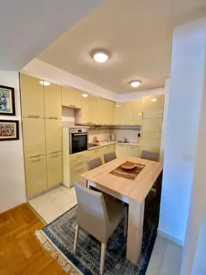 a kitchen with a wooden table and chairs at Danilo's apartment in Podgorica
